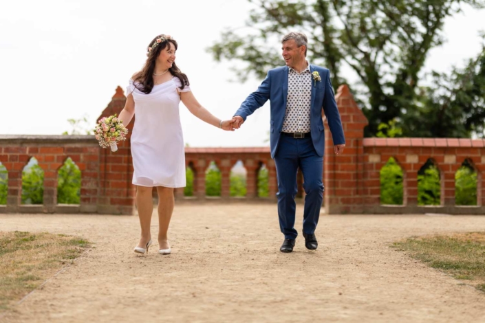 Hochzeit Tangermünde | Brautpaar Hand in Hand im Schlosspark