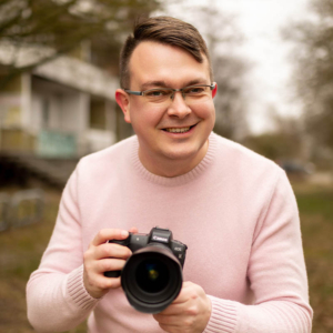 Andreas, Hochzeitsfotograf aus Stendal, hält Kamera, vertieft in die Kunst der Fotografie.