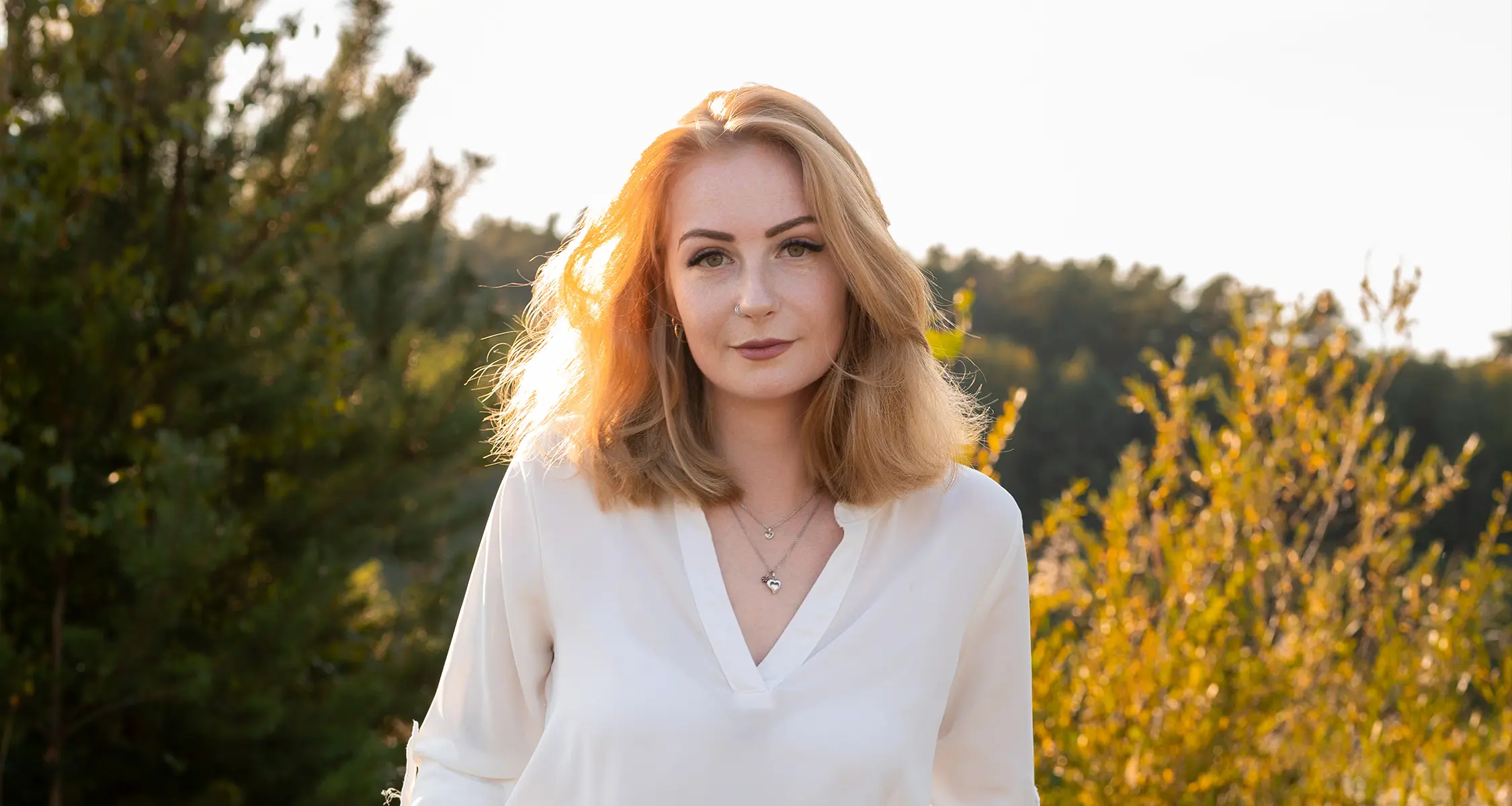 Celine beim Fotoshooting am See in Stendal, lächelt entspannt in die Kamera mit Sonnenlicht im Haar
