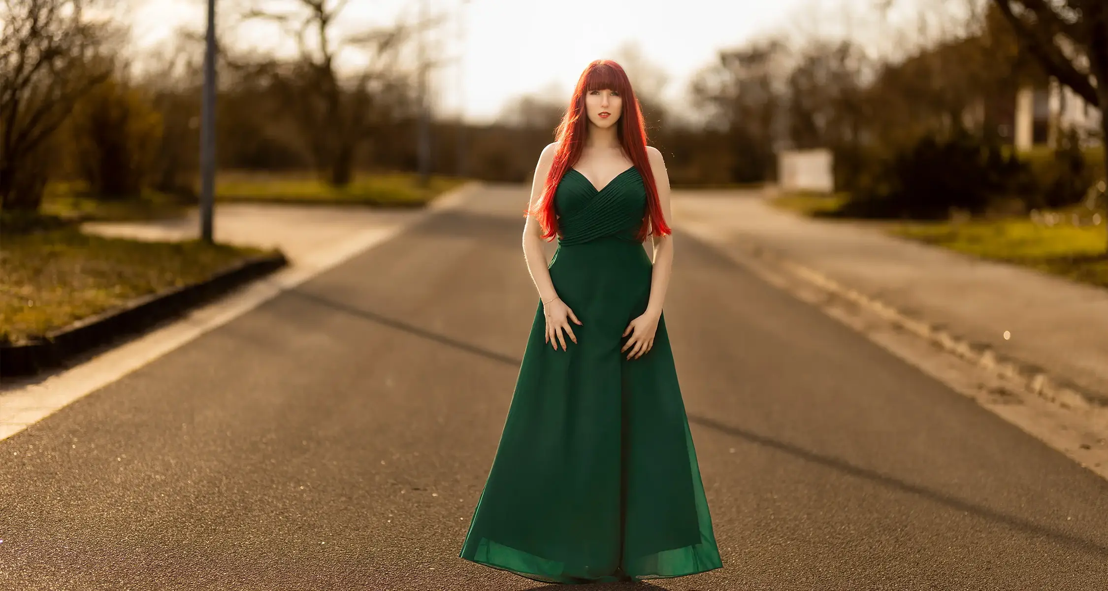 Christin im langen grünen Kleid auf leerer Straße in Stendal Süd beim Fotoshooting