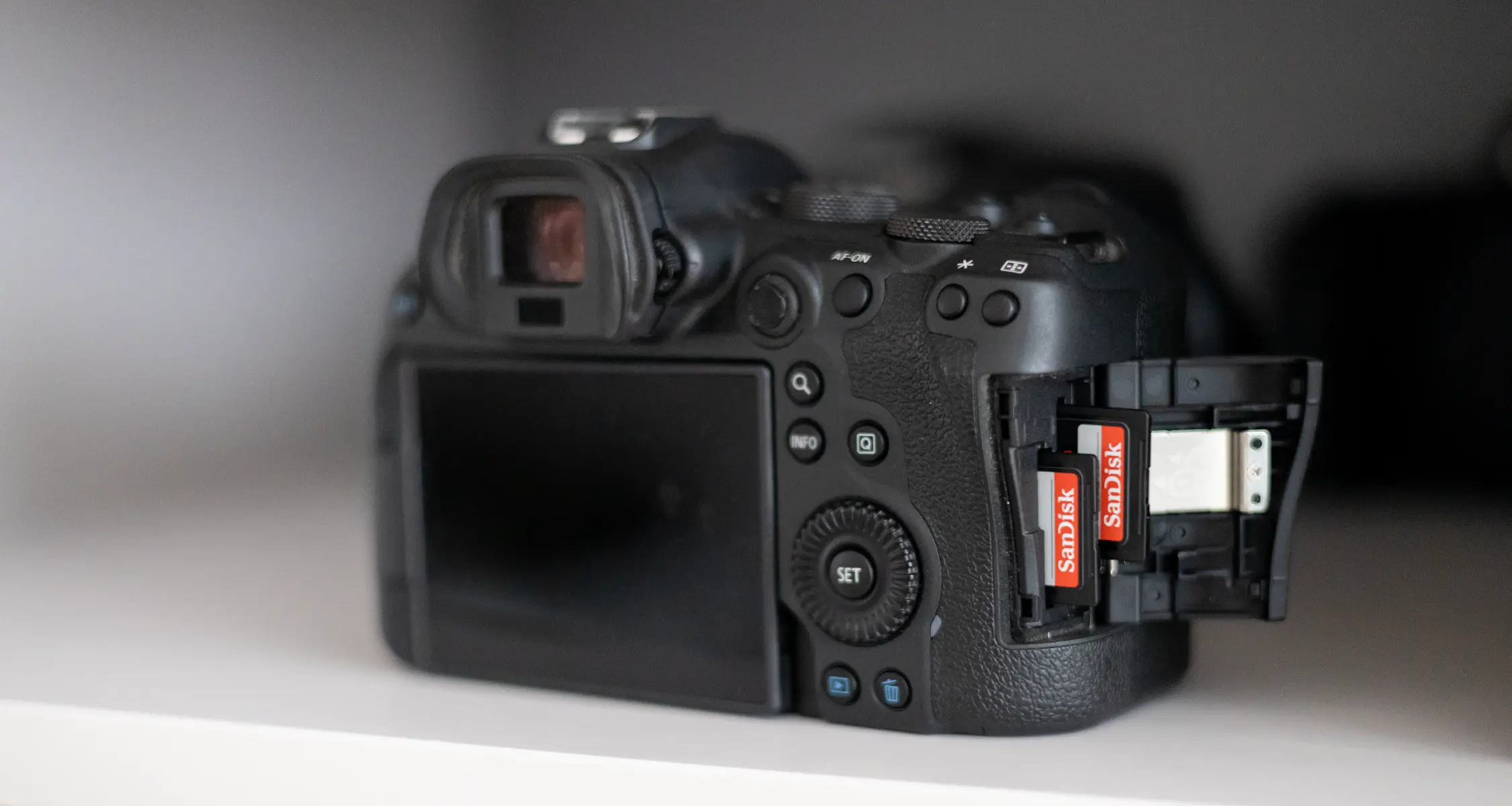 Rückansicht einer Kamera mit geöffnetem Speicherkartenfach und zwei SanDisk-Karten